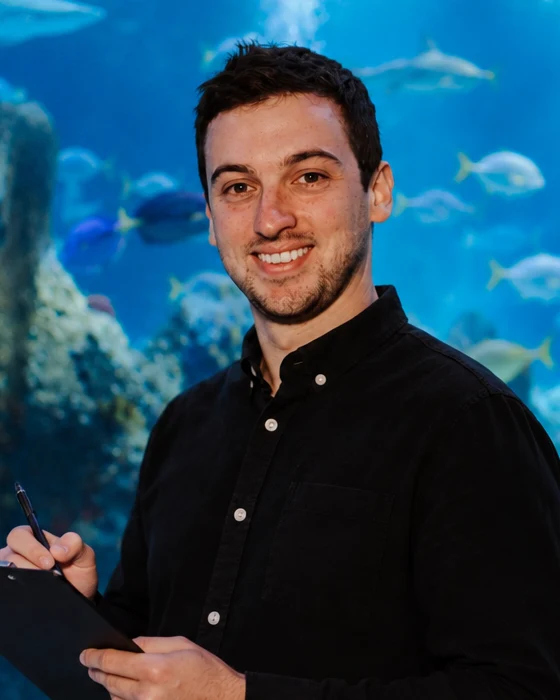 Joe Lavery, founder of Curious, in front of a reef aquarium